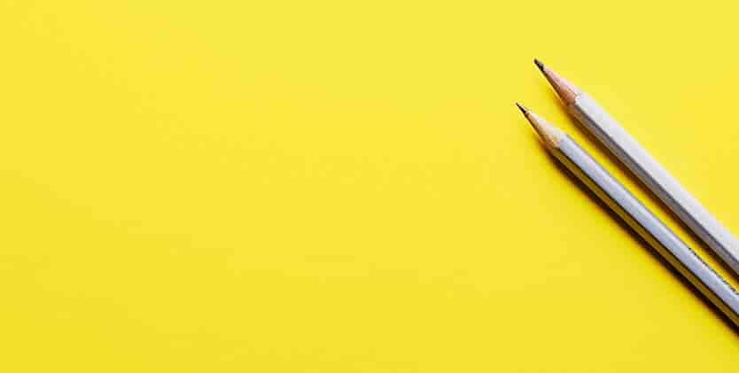 two-colored-pencils-on-yellow-background